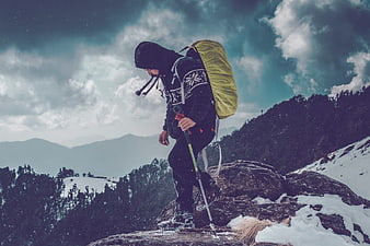 Hiker with Backpack on Snowy Mountain Peak