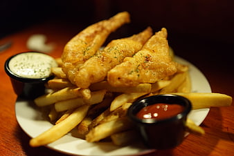 Golden fried fish and chips with tartar sauce and ketchup