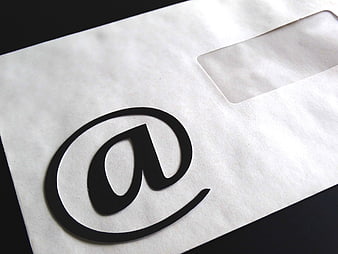 Black At-Sign Symbol Cutout on White Paper Envelope