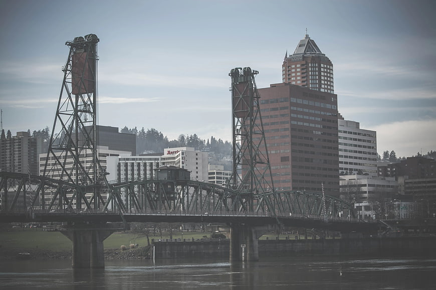 Steel Lift Bridge Over River With City Skyline