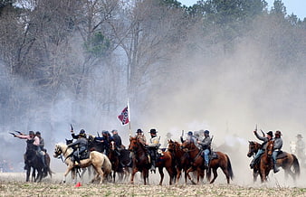 Civil War reenactment cavalry charge with smoke and flag