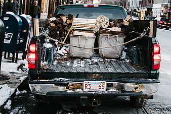 Rear view of pickup truck loaded with firewood in winter
