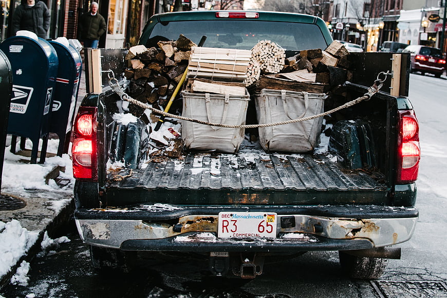Rear view of pickup truck loaded with firewood in winter