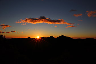 Sunset over Mountain Silhouette with Starburst Effect