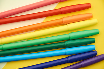 Colorful Markers Arranged on Yellow Background