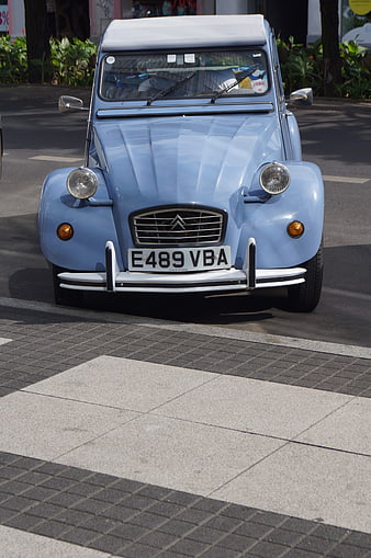 Front view of classic light blue Citroën 2CV on street