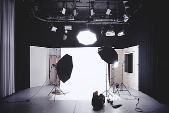 Professional photography studio setup with lighting equipment and white backdrop
