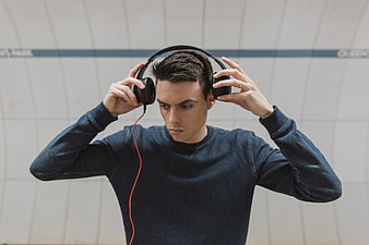 Young Man Listening to Music with Headphones in Subway