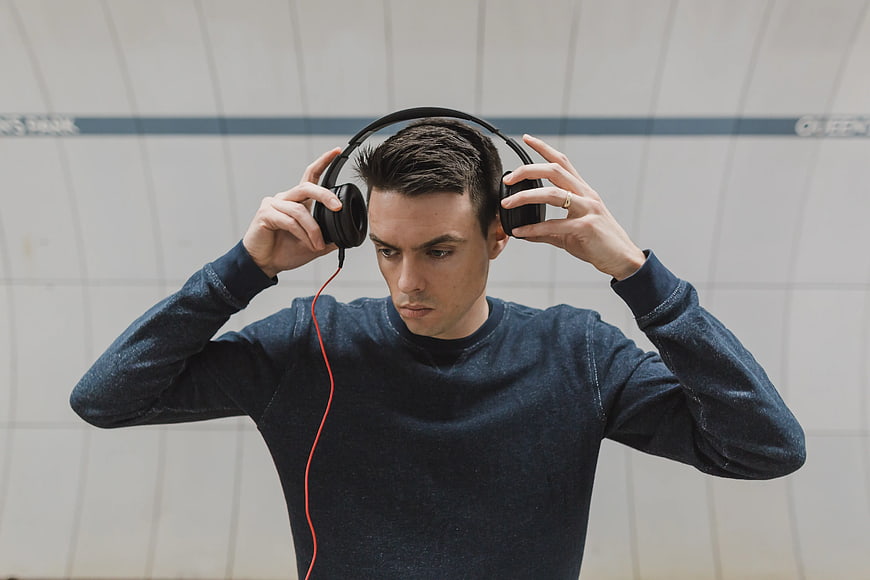 Young Man Listening to Music with Headphones in Subway