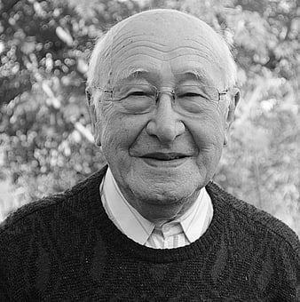 Black and white portrait of a smiling elderly man with glasses