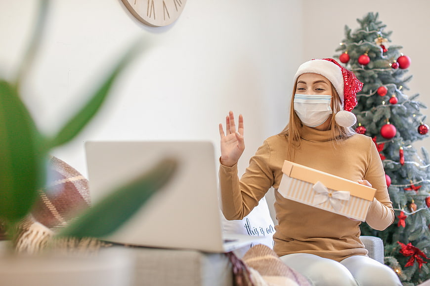 Woman in Santa Hat and Face Mask Video Calling with Christmas Gift