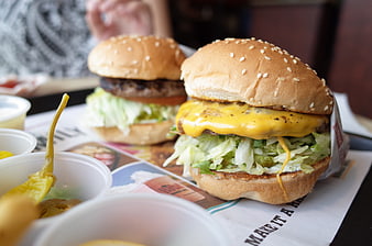 Cheeseburger with lettuce and pickles on restaurant paper