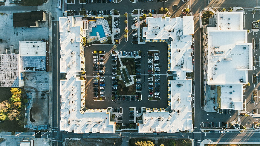 Aerial view of modern apartment complex with parking lot