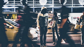 Anonymous Hooded Man Standing in Busy Night City Street