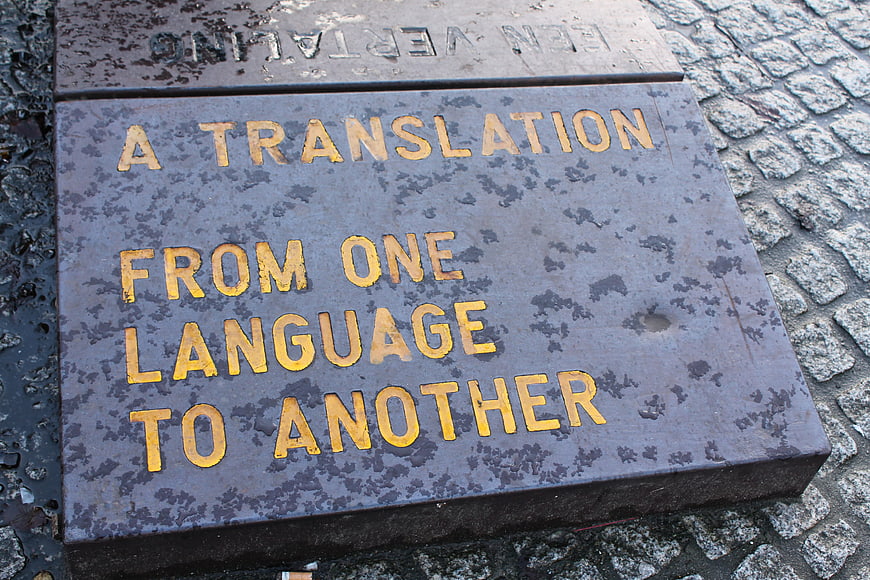Close-up of a stone plaque with the text A Translation From One Language To Another