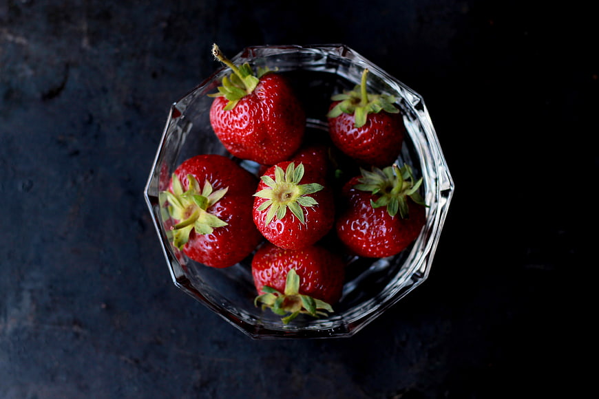 Top View of Fresh Strawberries in Glass Bowl on Dark Background