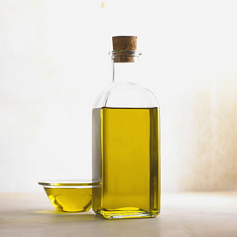 Glass Bottle of Golden Olive Oil with Small Bowl