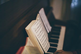 Close-up of sheet music on piano with blurred keys