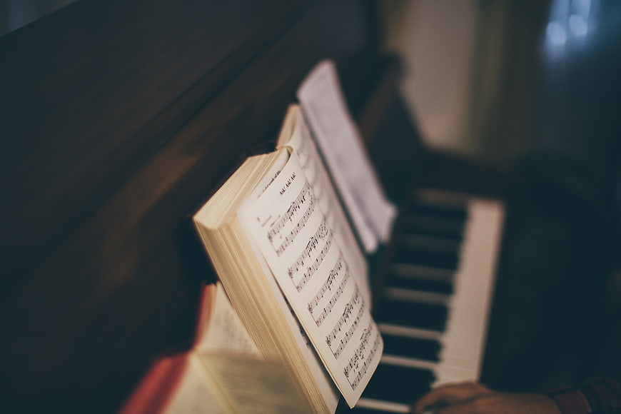 Close-up of sheet music on piano with blurred keys