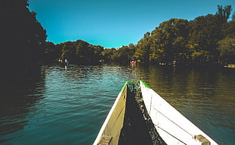 First-person view from a wooden boat on a calm river
