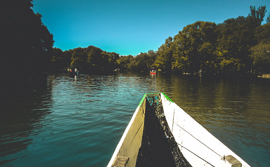 First-person view from a wooden boat on a calm river