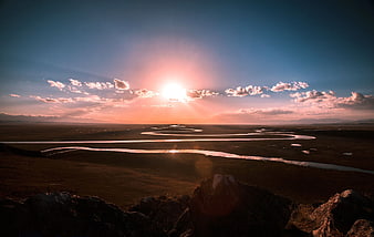 Sunset Over Winding River in Vast Landscape