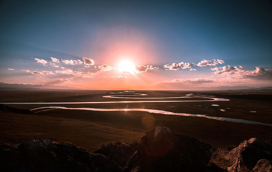 Sunset Over Winding River in Vast Landscape
