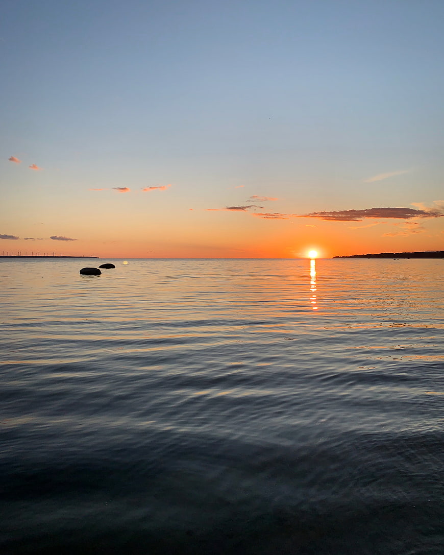 Serene Sunset Over Calm Ocean with Golden Reflection