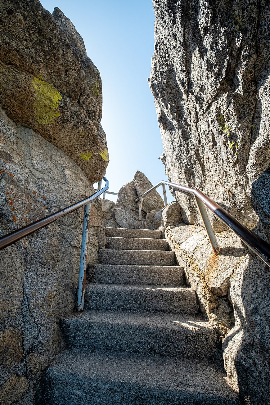 Stone stairs climbing between rocky cliffs to blue sky