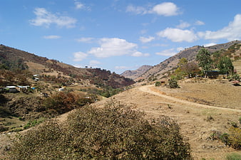 Rural Mexican mountain landscape with dirt road and scattered houses