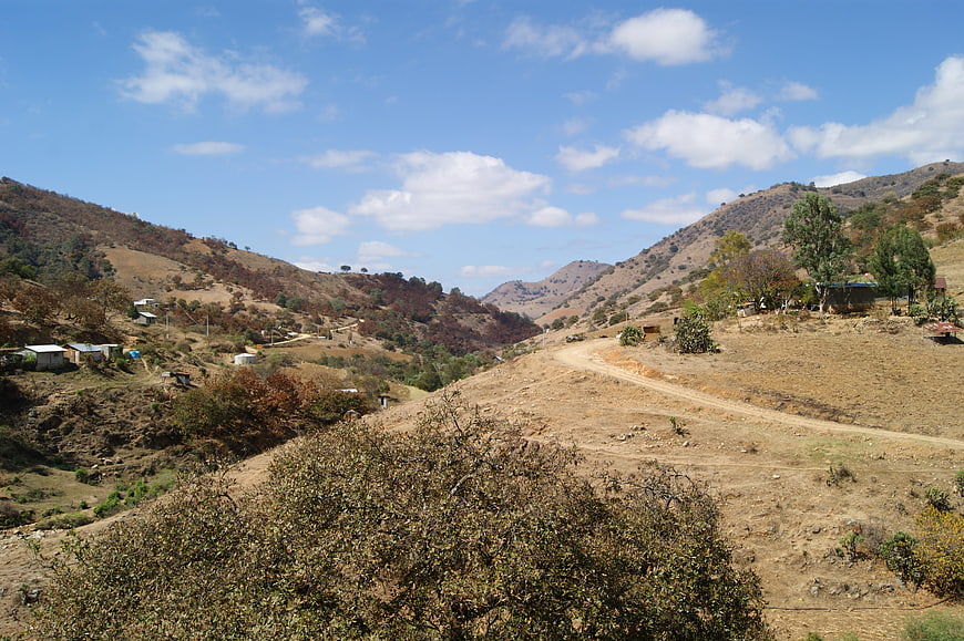 Rural Mexican mountain landscape with dirt road and scattered houses