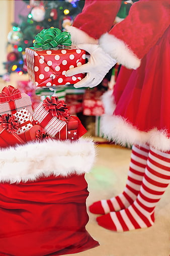 Santa Claus Placing Christmas Gifts Into Red Sack
