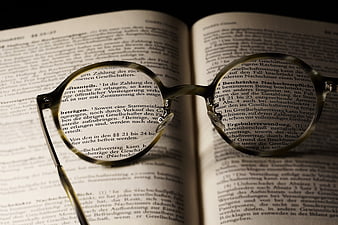 Reading glasses resting on open book pages with German legal text