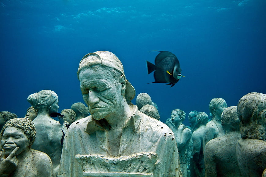 Underwater Sculpture Museum with Fish Swimming Past