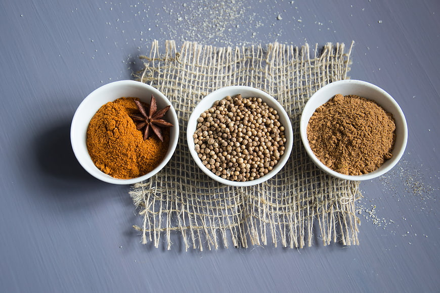 Top view of spices in white bowls on burlap