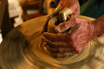 Close-up of hands shaping clay on a spinning pottery wheel