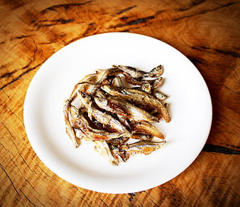 Fried Small Fish on White Plate on Rustic Wooden Table