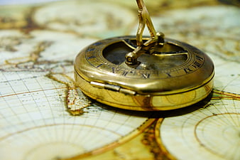 Antique brass compass resting on a vintage world map