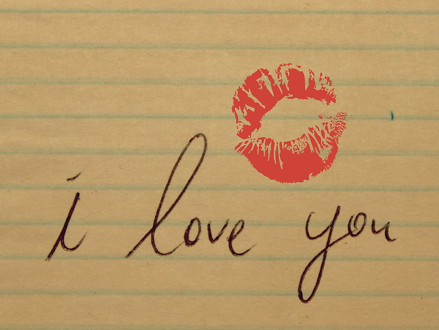 Handwritten i love you note with red lipstick kiss print on lined paper