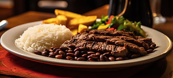 Brazilian steak dinner with rice, beans, and fries
