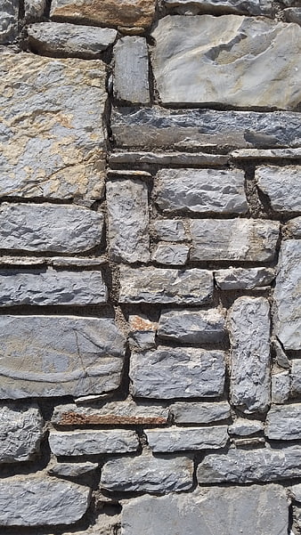 Close-up of textured gray stone wall masonry