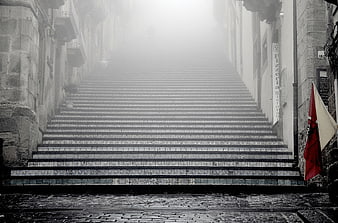 Foggy Stone Staircase in Old European Town with Red Flag