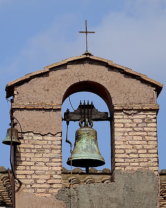 Old Church Bell Tower with Cross Against Blue Sky