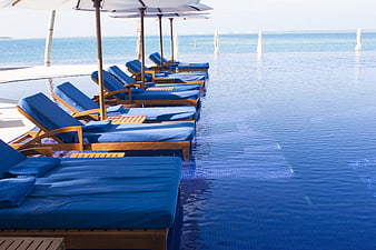 Luxury Blue Loungers At Infinity Pool Edge In Maldives