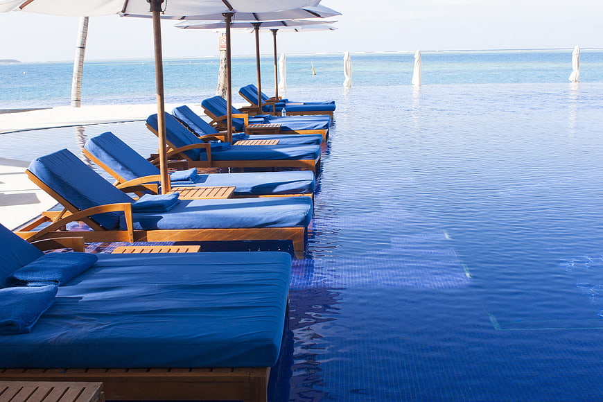 Luxury Blue Loungers At Infinity Pool Edge In Maldives