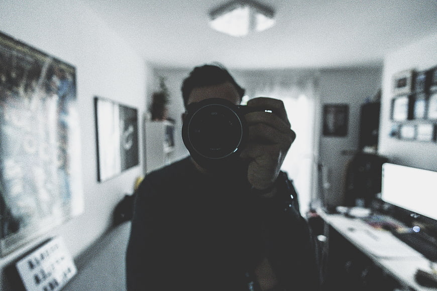 Man Taking Mirror Selfie with Camera in Home Office