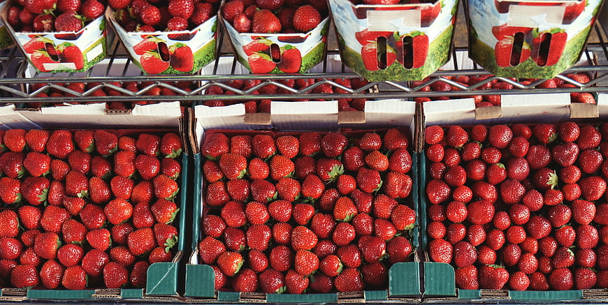 Fresh red strawberries in cardboard boxes at market