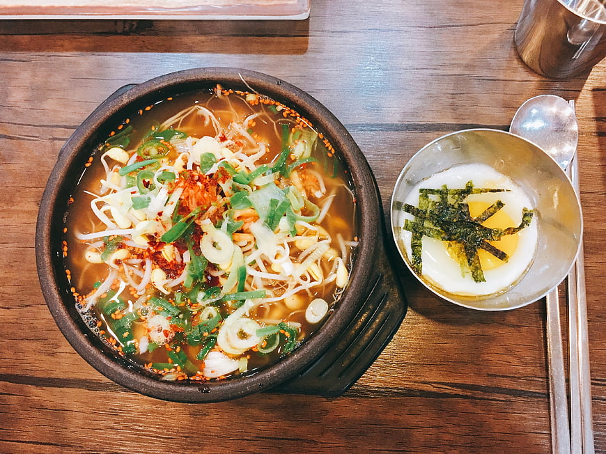 Korean Spicy Noodle Soup With Egg And Seaweed On Wooden Table