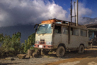 Rusty vintage bus parked on rural mountain road