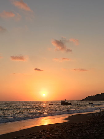 Serene Sunset Over Ocean Beach with Golden Sky